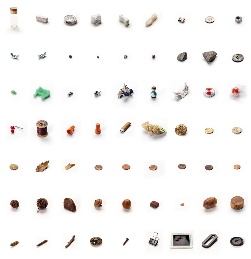 Lenka Clayton, "63 Objects Taken from my Son's Mouth", (2011–2012), materials as described by Clayton: "acorn, bolt, bubblegum, buttons, carbon paper, chalk, Christmas decoration, cigarette butt, coins (GBP, USD, EURO), cotton reel, holly leaf, little wooden man, sharp metal pieces, metro ticket, nuts, plastic “O”, polystyrene, rat poison (missing), seeds, slide, small rocks, specimen vial, sponge animal, sticks, teabag, wire caps, wooden block". Image courtesy lenkaclayton.com.