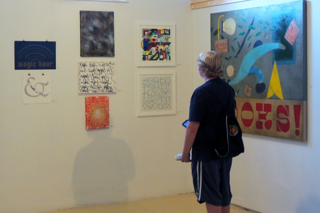 A viewer looks at the work in "Ode to Letters" at Engine in Biddeford. Photo by the author.